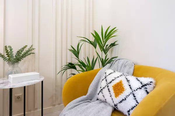 Comfortable room with an upholstered armchair, pillow, and blanket